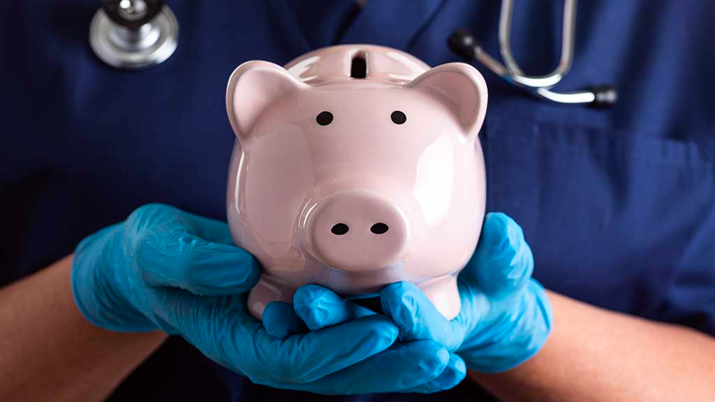 A nurse holding a piggybank in their gloved hands